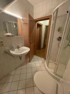 a bathroom with a sink and a shower at Hotel und Restaurant Grüner Hahn in Elsenfeld