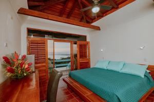 a bedroom with a bed and a view of the ocean at Hotel Planeta Sano in Manuel Antonio