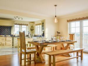 a dining room with a wooden table and chairs at Drummygar Mains in Carmyllie