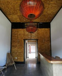 a hallway with two red chandeliers hanging from a ceiling at Chale's House Hotel in San Juan del Sur