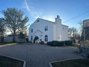 ein weißes Haus mit einer Einfahrt davor in der Unterkunft Taber Inn in Mystic