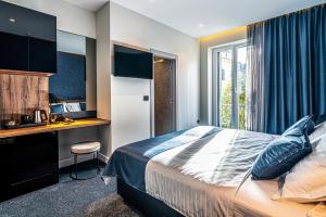 a hotel room with a bed and a desk and a window at Calma Luxury Rooms in Split