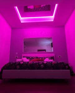 ein rosafarbenes Zimmer mit einem Bett und einem großen Spiegel in der Unterkunft B&B da Mary in Matrice