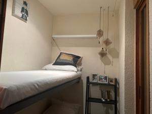 um pequeno quarto com uma cama e uma pequena prateleira em HotSpot Valencia em Valência