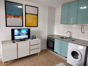 a kitchen with a washing machine and a tv on a counter at Acuarium 3 studio - Zand Properties in Benidorm