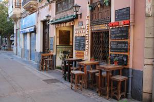 a row of tables and stools in front of a store at HotSpot Valencia in Valencia