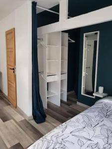 een slaapkamer met een bed en een spiegel bij Nuitées / télétravail in Duinkerke