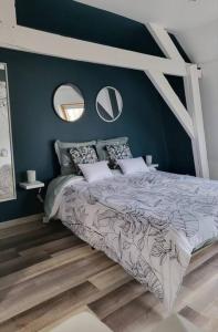 een slaapkamer met een bed met blauwe muren en spiegels bij Nuitées / télétravail in Duinkerke