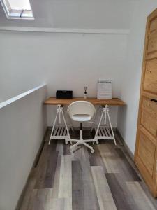 een bureau met een witte stoel in een kamer bij Nuitées / télétravail in Duinkerke