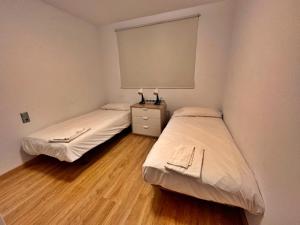 two beds in a small room with a window at Ribasol 645, apartamento hasta 4 personas, Arinsal in Arinsal