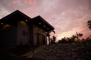 een huis met een zonsondergang op de achtergrond bij Jungle Home with King Beds -5 Minutes from the Beach in Uvita