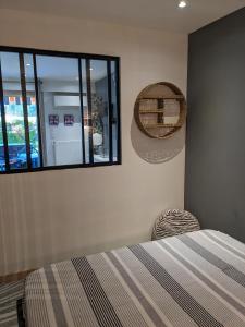 Schlafzimmer mit einem Bett und einem Wandspiegel in der Unterkunft Golfe Paradis in Vallauris