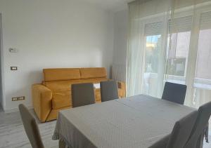 ein Esszimmer mit einem Tisch, Stühlen und einem Sofa in der Unterkunft La Magnolia Apartments III in Desenzano del Garda