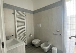 ein Bad mit einem WC, einem Waschbecken und einer Dusche in der Unterkunft La Magnolia Apartments III in Desenzano del Garda