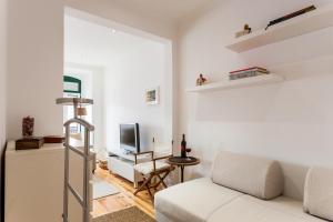 een woonkamer met een witte bank en een televisie bij Apartment Príncipe Real Area in Lissabon