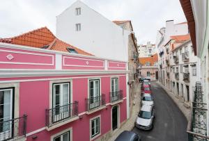 een straat met roze gebouwen en auto's op straat bij Apartment Príncipe Real Area in Lissabon