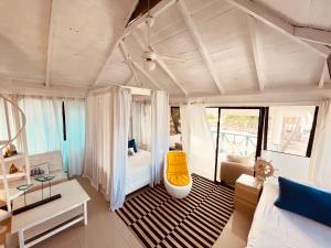 een woonkamer met een bed en een bank bij Bluemare EcoHotel Frente a la playa Ensendada in Punta Rucia