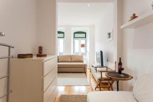 een woonkamer met een bank en een tafel bij Apartment Príncipe Real Area in Lissabon