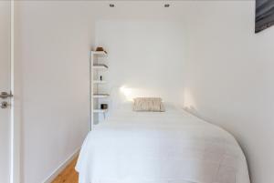 een witte slaapkamer met een bed in een witte muur bij Apartment Príncipe Real Area in Lissabon