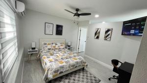 a bedroom with a bed and a desk and a tv at VillaBella in Fort Myers