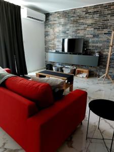 sala de estar con sofá rojo y pared de ladrillo en 2 Bedroom Apartment in San Gwann, en San Ġwann