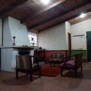 sala de estar con 2 sillas y chimenea en Pululahua Magia y Encanto, en Quito