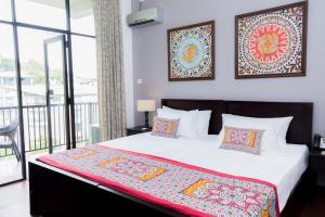 um quarto com uma cama grande e uma varanda em Kandy City View em Kandy