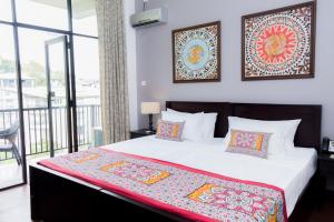 a bedroom with a large bed and a balcony at Kandy City View in Kandy