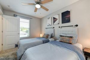 two beds in a bedroom with a ceiling fan at Sacramento Two-Story Condo Near Oak Park Brewing! in Sacramento