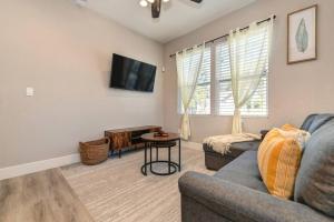 a living room with a couch and a tv at Sacramento Two-Story Condo Near Oak Park Brewing! in Sacramento