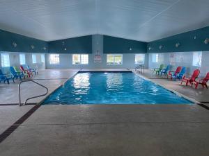 a large swimming pool with colorful chairs in a building at Taber Inn in Mystic