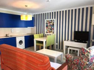 sala de estar con sofá y cocina con armarios azules en Verano Azul, en Vera