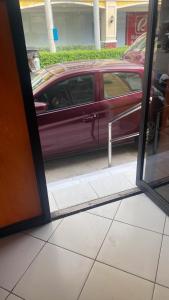 a reflection of a red car in a window at ROMY'S PLACE - ENTIRE 2ND FLOOR APARTMENT in Vigan