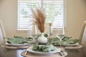 a table with plates and glasses and a vase with grass at NEW Upscale House, Tahoe 30-min w/ Cal King in Steamboat