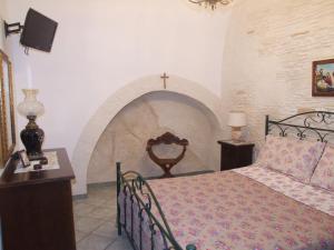 a bedroom with a bed with a cross on the wall at La Tana del Lupo in Oria