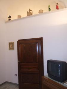 オーリアにあるLa Tana del Lupoのテレビ、棚、ドア付きの部屋