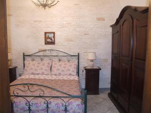 1 dormitorio con cama negra y almohadas rosas en La Tana del Lupo, en Oria