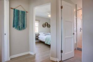 a bedroom with a bed and a door leading into a room at Ocean Beach Retreat 2BR Newly Remodeled, 2 Blocks to Sand and Shops in San Diego