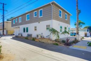 a white house with blue windows on a street at Ocean Beach Retreat 2BR Newly Remodeled, 2 Blocks to Sand and Shops in San Diego