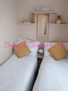 two beds sitting next to each other in a room at Becky's Caravan at Marton Mere in Blackpool