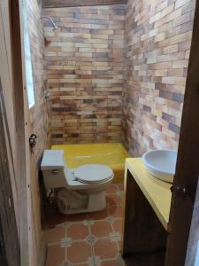 a bathroom with a toilet and a sink and a tub at Pululahua Magia y Encanto in Quito