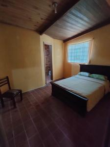 1 dormitorio con 1 cama grande y 1 silla en Pululahua Magia y Encanto en Quito