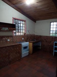 a kitchen with a stove and a sink in it at Pululahua Magia y Encanto in Quito