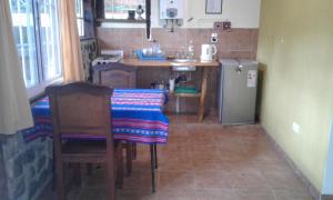 a small kitchen with a table and a refrigerator at Casa-monte in San Marcos Sierras