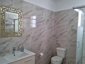 a bathroom with a toilet and a sink and a mirror at Ma Maison Rose in Kremasti +48 photos