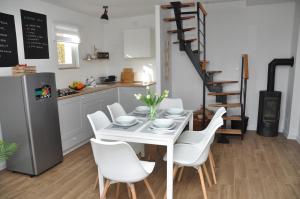 Kutjevo的住宿－Holiday home Vinovilla，厨房以及带白色桌椅的用餐室。