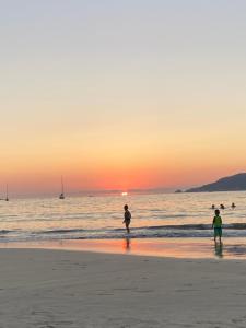 two people standing on the beach at sunset at Casa ALOA Ixtapa in Ixtapa