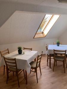 a dining room with two tables and chairs and a skylight at Gasthaus am Schloss in Karlsburg