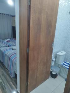 a door to a bedroom with a bed and a toilet at Casa da família em Aparecida tv wi fi 4 banheiros à 5 min da Basílica in Aparecida