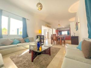 ein Wohnzimmer mit einem Sofa und einem Tisch in der Unterkunft Luxury 4 bedroom villa with a heated pool in Hurghada